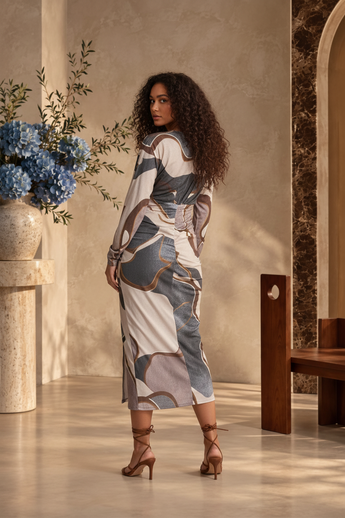Bleu Hanger midi dress with abstract multicolor print, long sleeves, and ruched skirt, worn by a model in a studio.